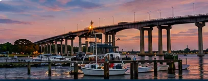 Waterfront bridge and marina at sunset, showing the river setting around Newport News